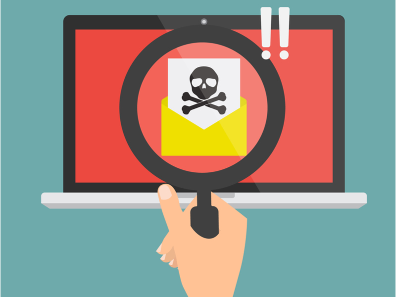 זכוכית מגדלת על גבי מסך עם מעטפה וסימן של גולגולת (דימוי לדוא"ל חשוד) 